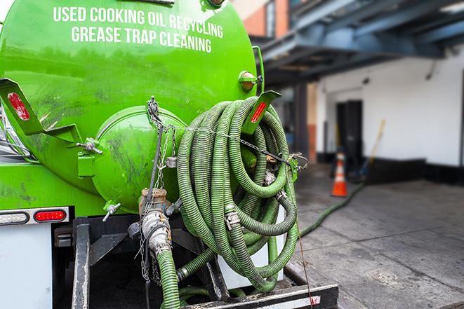 a technician pumping a grease trap in a commercial building in Montgomery Village, MD